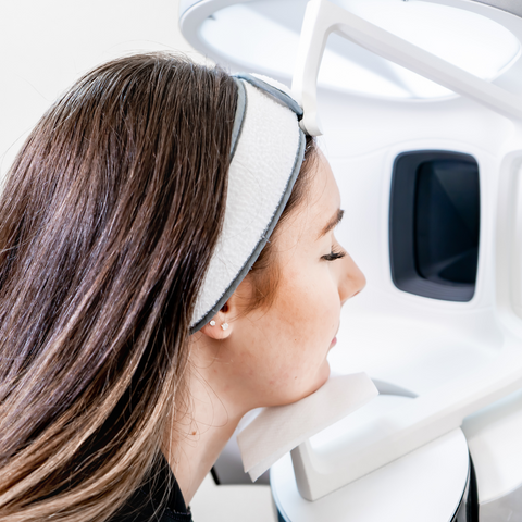 Young woman undergoing a professional skin analysis with advanced dermatology equipment, used to assess skin health and measure anti-ageing treatment results